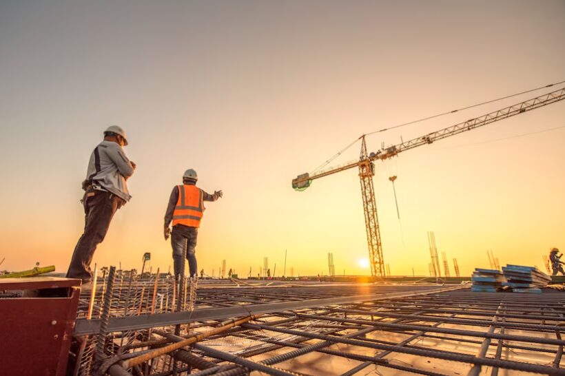 Equipe em obra de construção civil ao entardecer